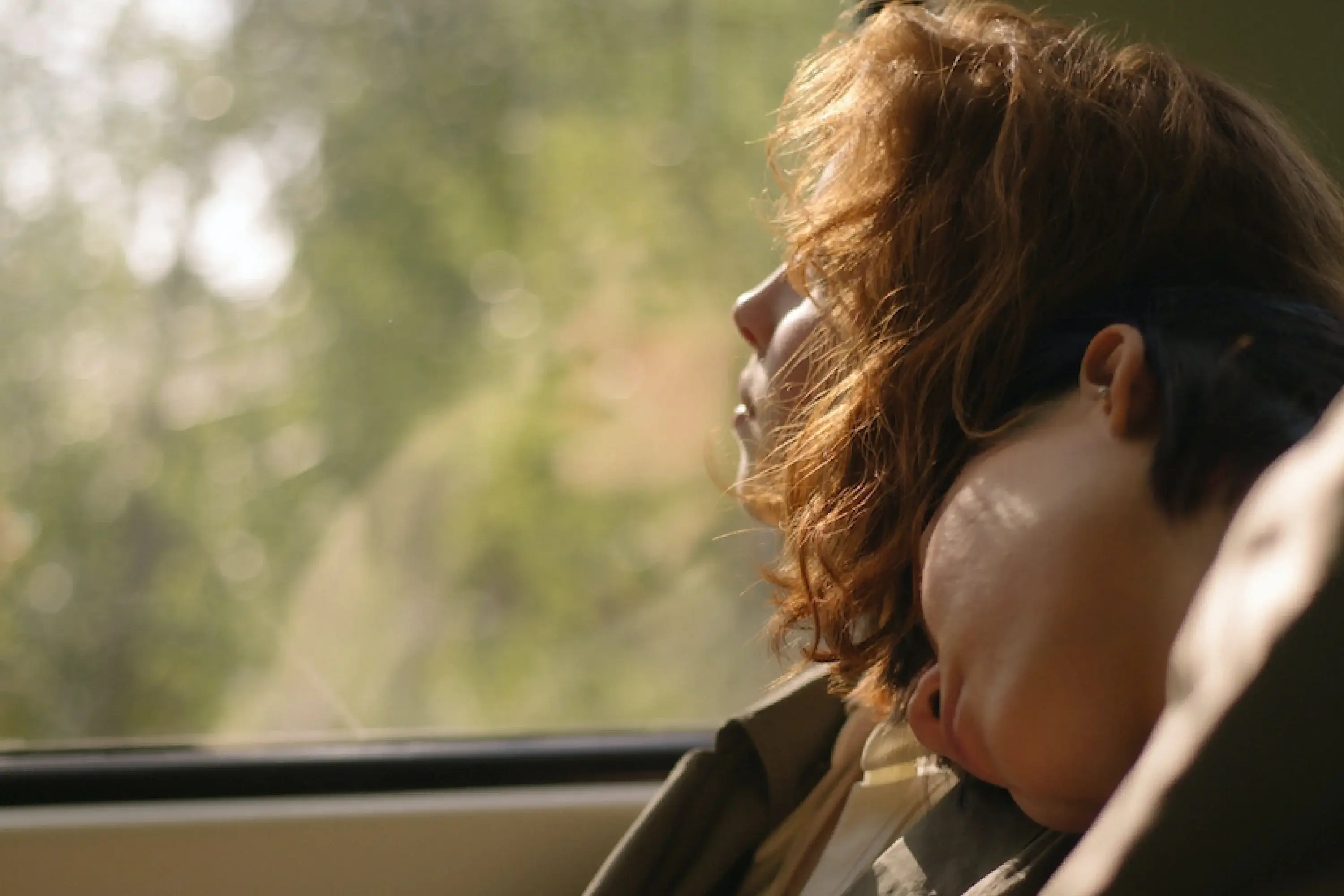 woman looking out a window at a forest